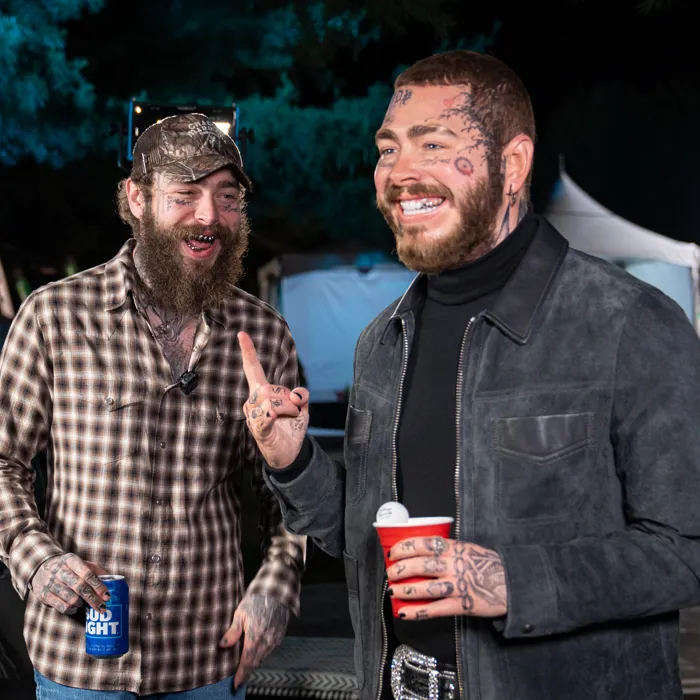 Post Malone smiling at wax figure